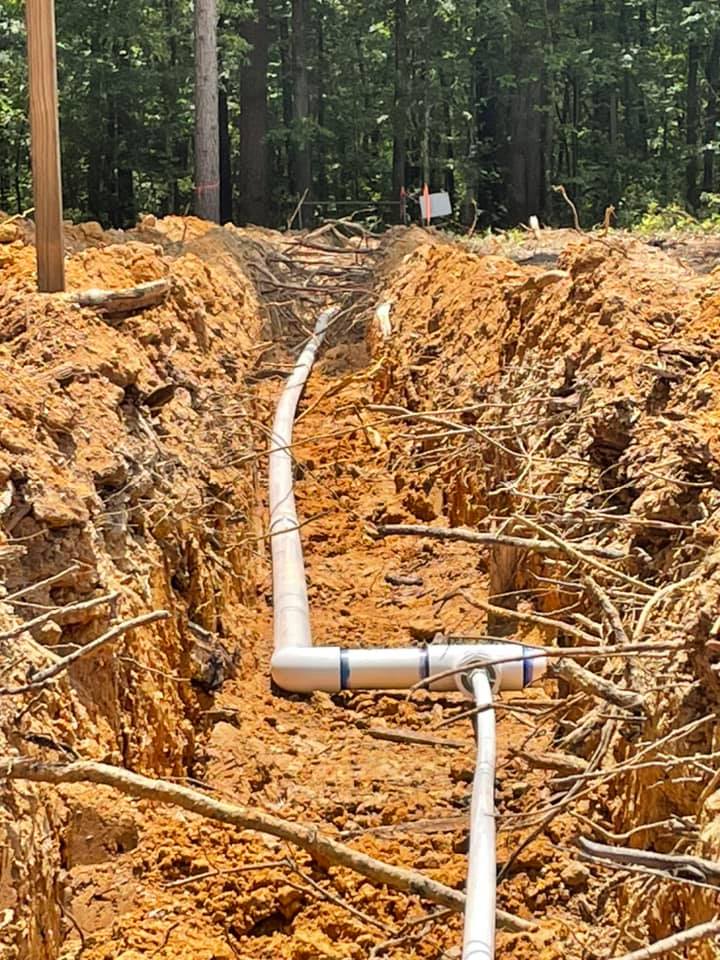 Underground sewer line installation in trench by licensed plumbing professionals.