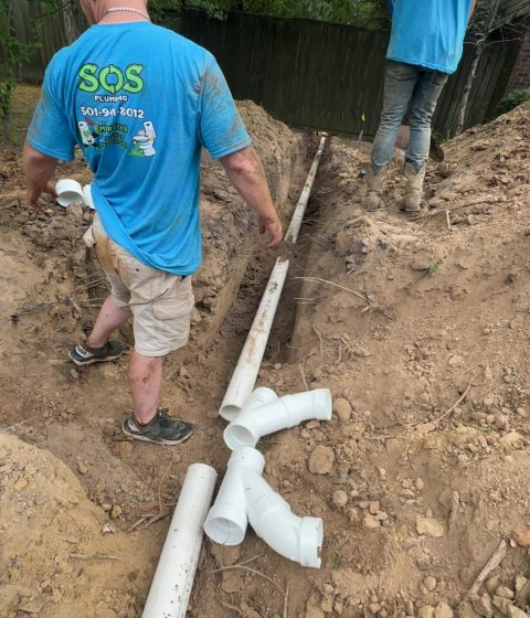 Construction site showing plumbers installing new sewer lines.